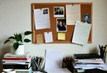 10 Reasons Why Education Is More Important Now Than Ever Chaotic desk with books, laptop, and pinned photos from low angle