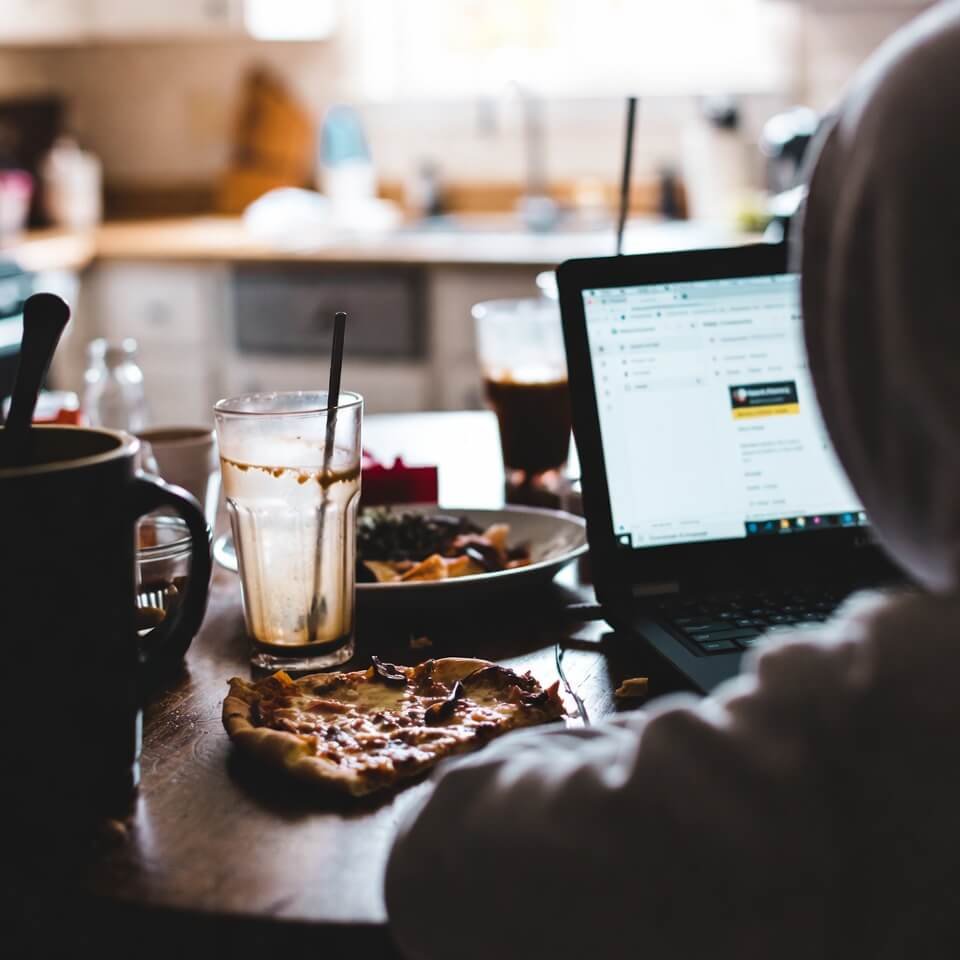 Messy kitchen table with cold pizza and Google Classroom open