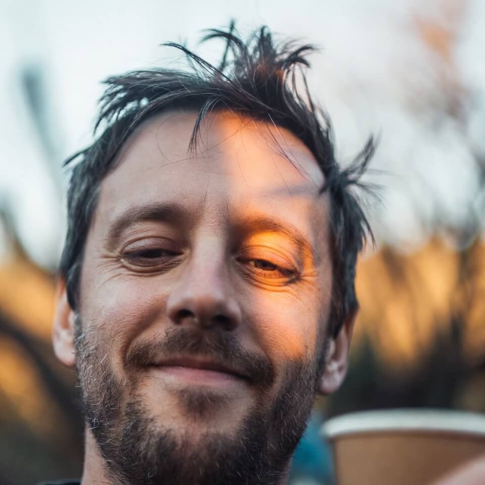 Exhausted but triumphant face at sunrise with coffee