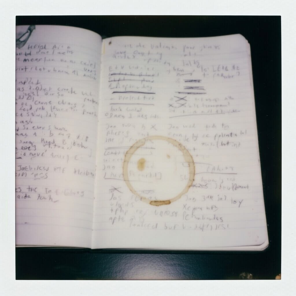Coffee-stained notebook tracking volunteer hours and crossed-out job apps.