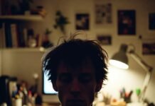 Best Careers for Introverts That Don’t Suck Your Energy Tired young man in dim workspace.